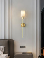 The Clérachic Mycara in copper on a fluted white wall, alabaster shade lit above a low bedside table.