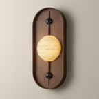 Clérachic throws a soft halo up and down the walnut back plate and onto the pale wall behind the lit orb.