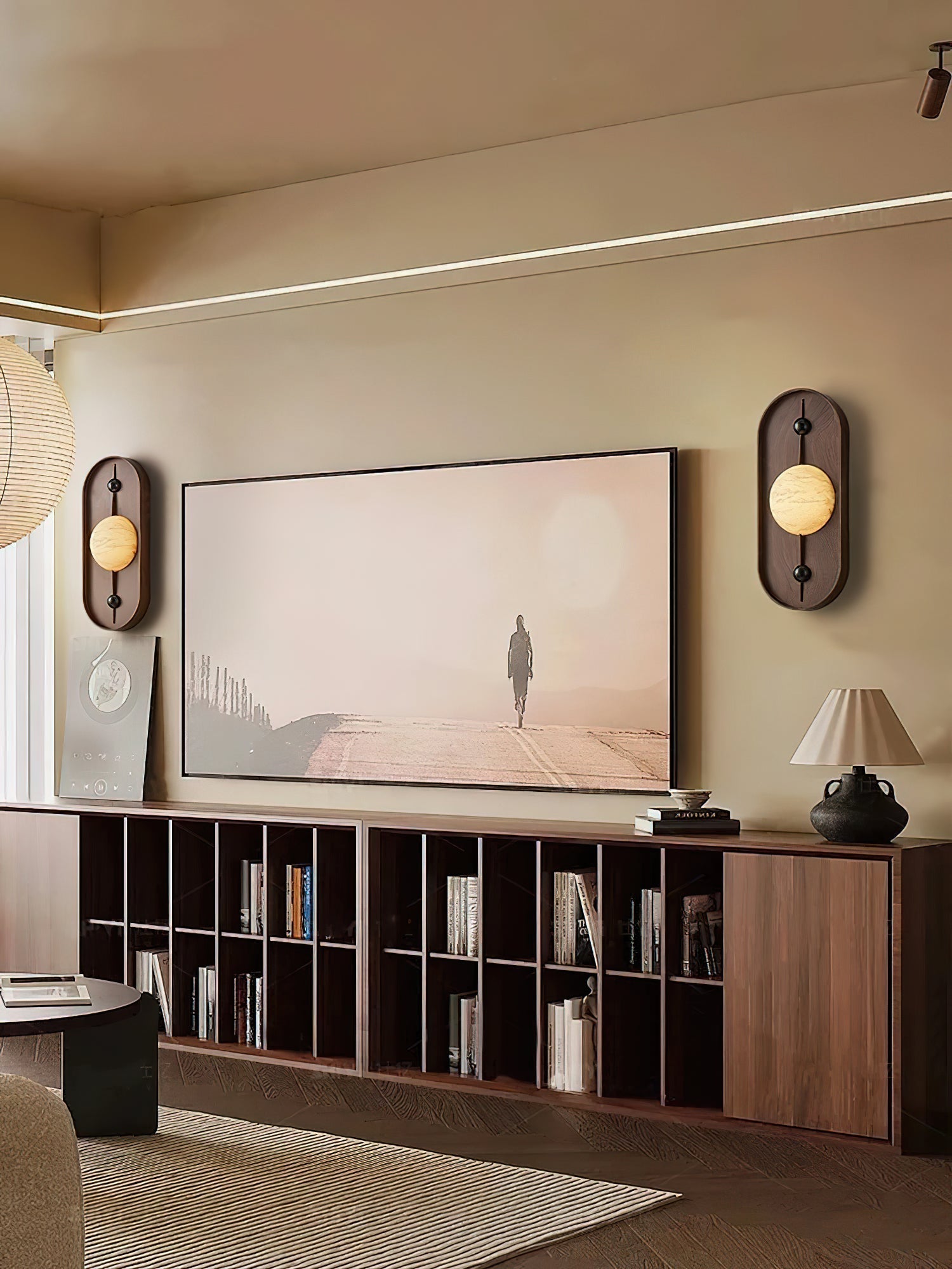 The Clérachic pair brackets a large screen in a low-lit living room lined with walnut shelving.