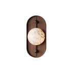 Clérachic shot flat on white: walnut oval, black end caps and a heavily veined alabaster orb at the centre.