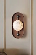 Clérachic lights a panelled wall, the sconce throwing a soft halo across the timber plate and the moulding behind.