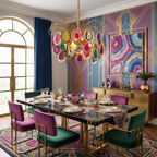 This Clérachic chandelier lit over a black dining table, with magenta and green velvet chairs and a purple and gold geometric wall.