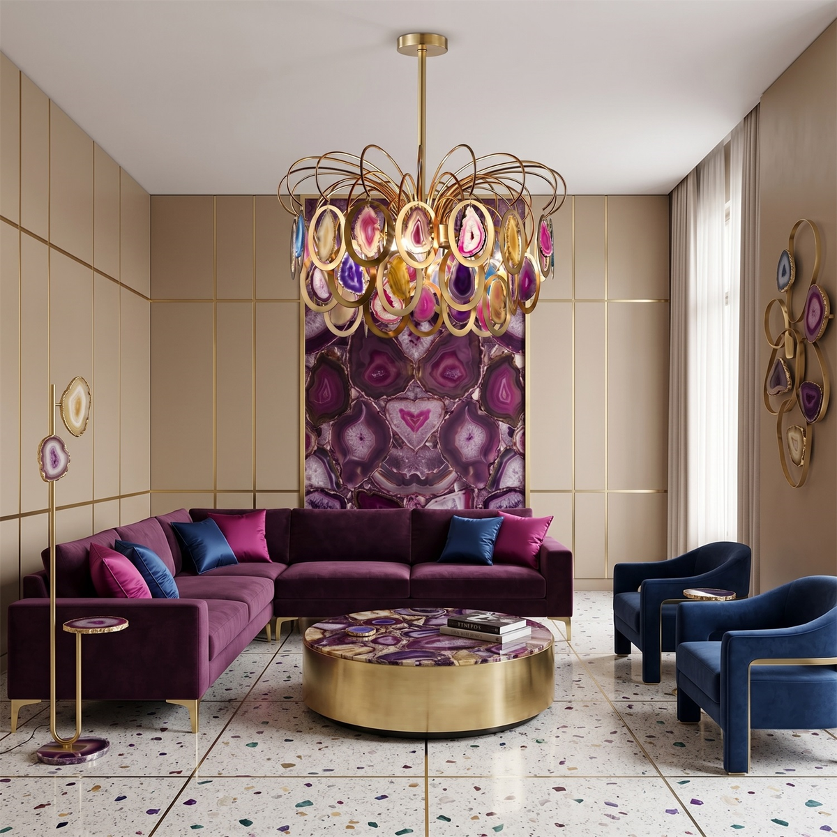 A Clérachic agate chandelier centred above a plum velvet corner sofa and a round gold coffee table in a cream panelled room.