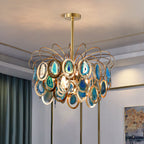 Blue-toned Clérachic agate chandelier in a pale room with teal curtains, its gold rings holding teal and sky-blue agate slices.