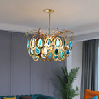 A Clérachic blue agate chandelier in a grey-panelled room with a tall green plant and a teal sofa at the edge of the frame.