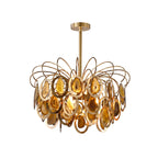 The yellow Clérachic agate chandelier on white, with honey and amber agate slices set in gold rings below looping brass wires.