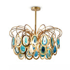 Closer view of the blue Clérachic agate chandelier, with teal slices in gold rings below looping brass wires, on white.