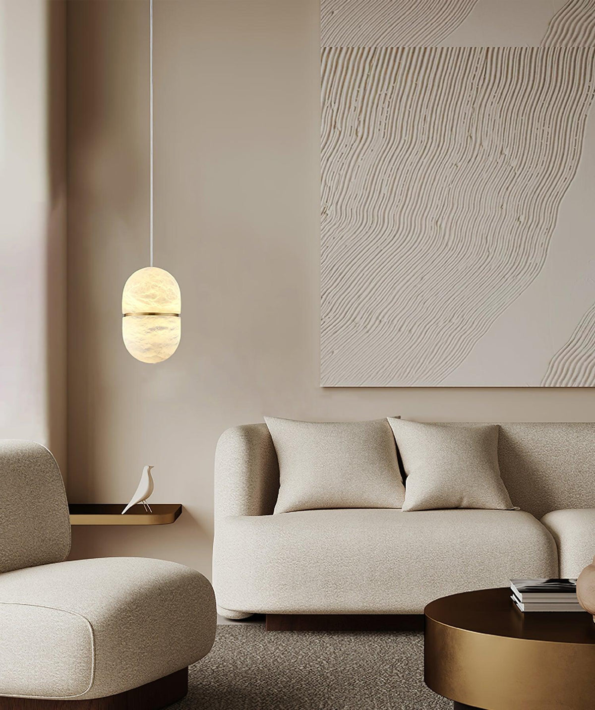 This Clérachic alabaster pendant glowing in a soft neutral room, with a boucle sofa, a textured artwork and a round brass table.