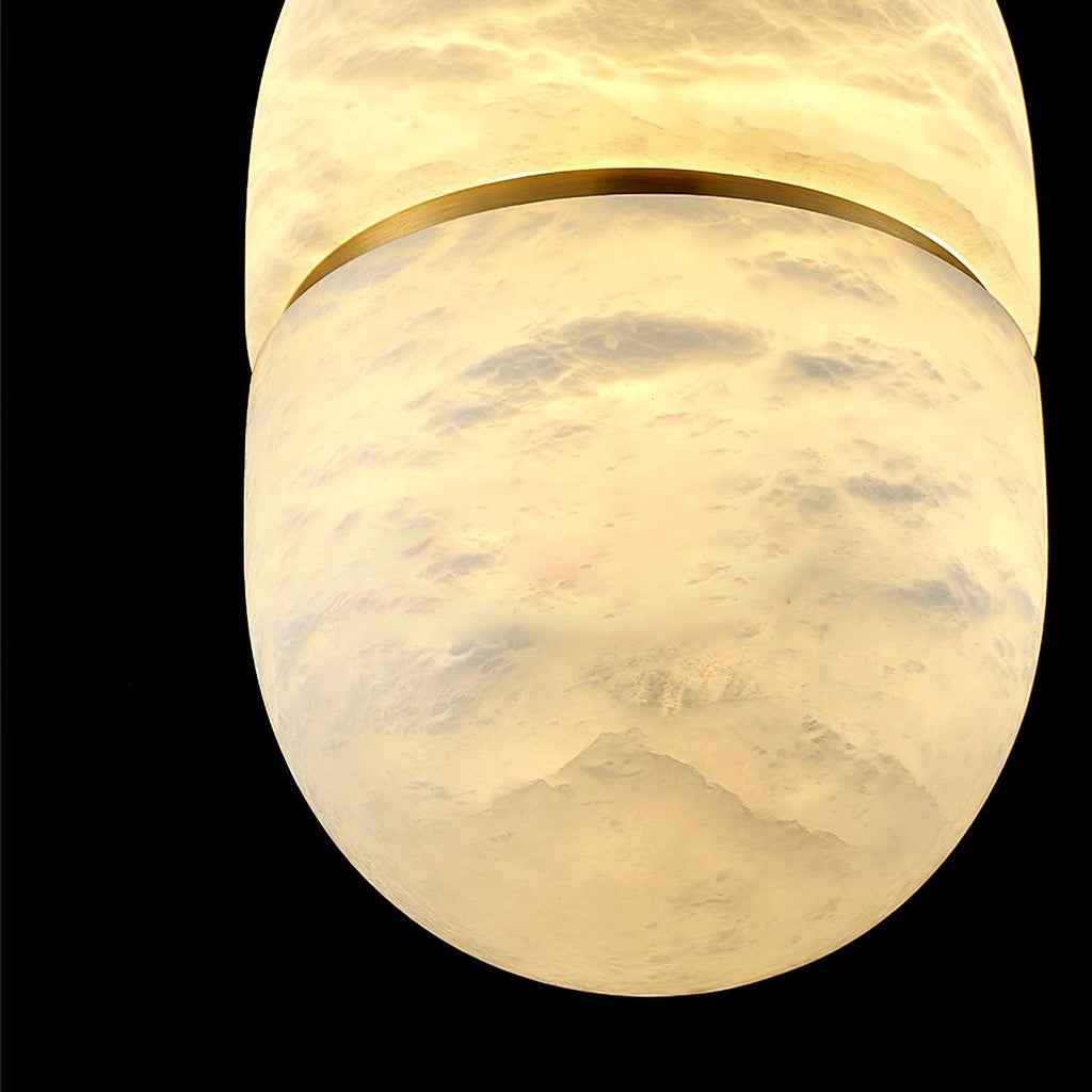 Very close view of the glowing alabaster of this Clérachic pendant, with cloud-like veining and the gold band across the middle.