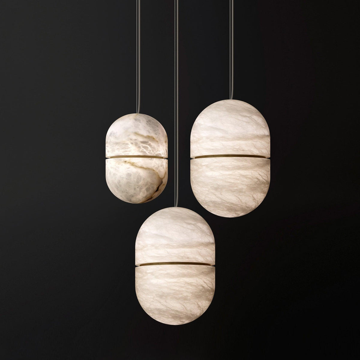 Three Clérachic alabaster pendants at different heights on a dark backdrop, each with a thin gold band and visible veining.