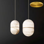 Two Clérachic alabaster pendants with gold bands and a gold round canopy at the top right, on a dark backdrop.