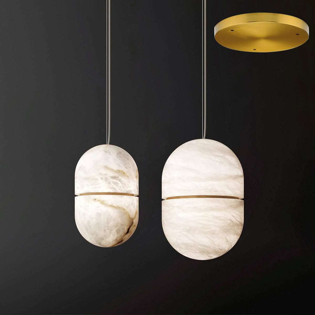 Two Clérachic alabaster pendants with gold bands and a gold round canopy at the top right, on a dark backdrop.