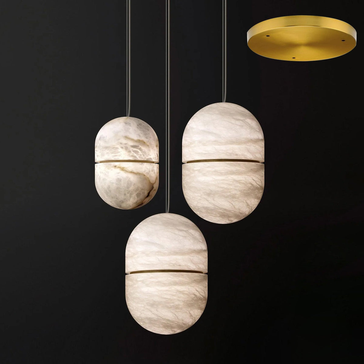 Three Clérachic alabaster pendants with gold bands, hung from a gold round canopy on a dark backdrop.