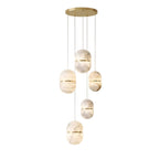 A cluster of six Clérachic alabaster pendants of varied sizes, hung at different heights from a gold canopy on white.