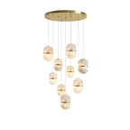 A nine-head Clérachic alabaster cluster with gold bands, hung from a wide gold round canopy on a white backdrop.