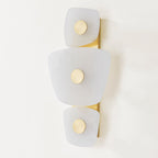 Unlit Clérachic alabaster wall sconce seen at an angle, the pale stone reading as quiet wall sculpture on a white wall.