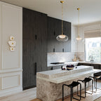 Clérachic alabaster wall sconce on the wall of a daylit kitchen with dark timber cabinetry and a marble island.