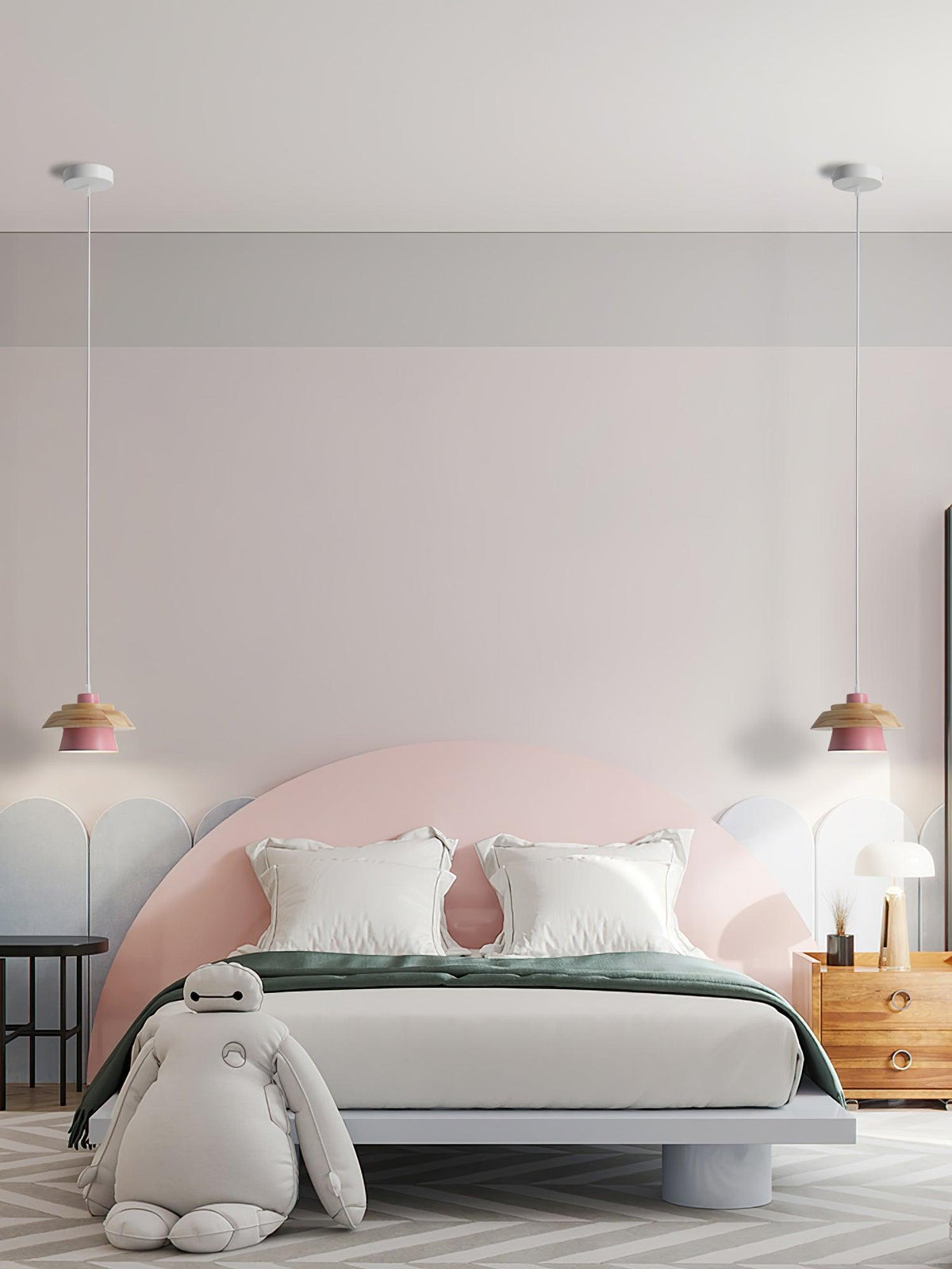 Two small pink-shaded Clérachic pendants hang by a pink arched headboard, with a large soft toy in front of the bed.
