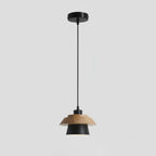 Black metal shade with a layered wood top, a black cord and a round black ceiling canopy, on a pale grey backdrop, from Clérachic.