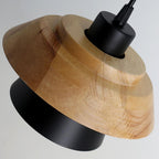 Close view of the layered wood top and black metal shade on this Clérachic pendant, with its black fitting above.