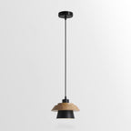 Black-shaded Clérachic pendant with a layered wood top and a round black ceiling canopy, on a plain light backdrop.