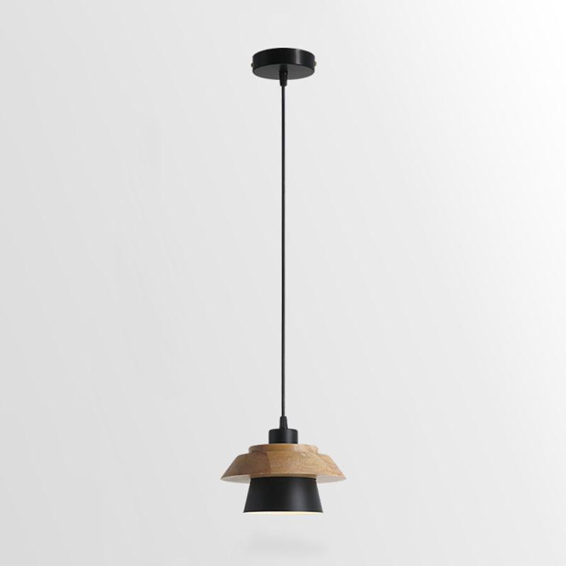 Black-shaded Clérachic pendant with a layered wood top and a round black ceiling canopy, on a plain light backdrop.