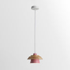 Pink-shaded Clérachic pendant with a wood top, on a white cord and a round white ceiling canopy, on a pale backdrop.