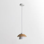 White-shaded Clérachic pendant with a layered wood top, on a white cord and a round white canopy, on a pale backdrop.