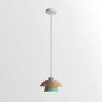 Green-shaded Clérachic pendant with a layered wood top, on a white cord and a round white canopy, on a pale backdrop.