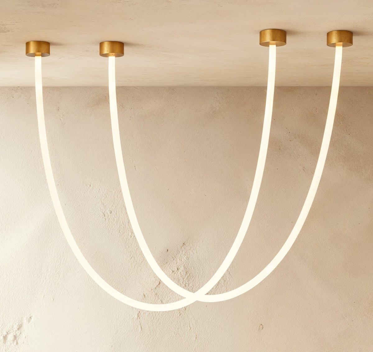 Clérachic gold-capped flexible LED chandelier loops in two glowing white arcs from a plaster ceiling corner.