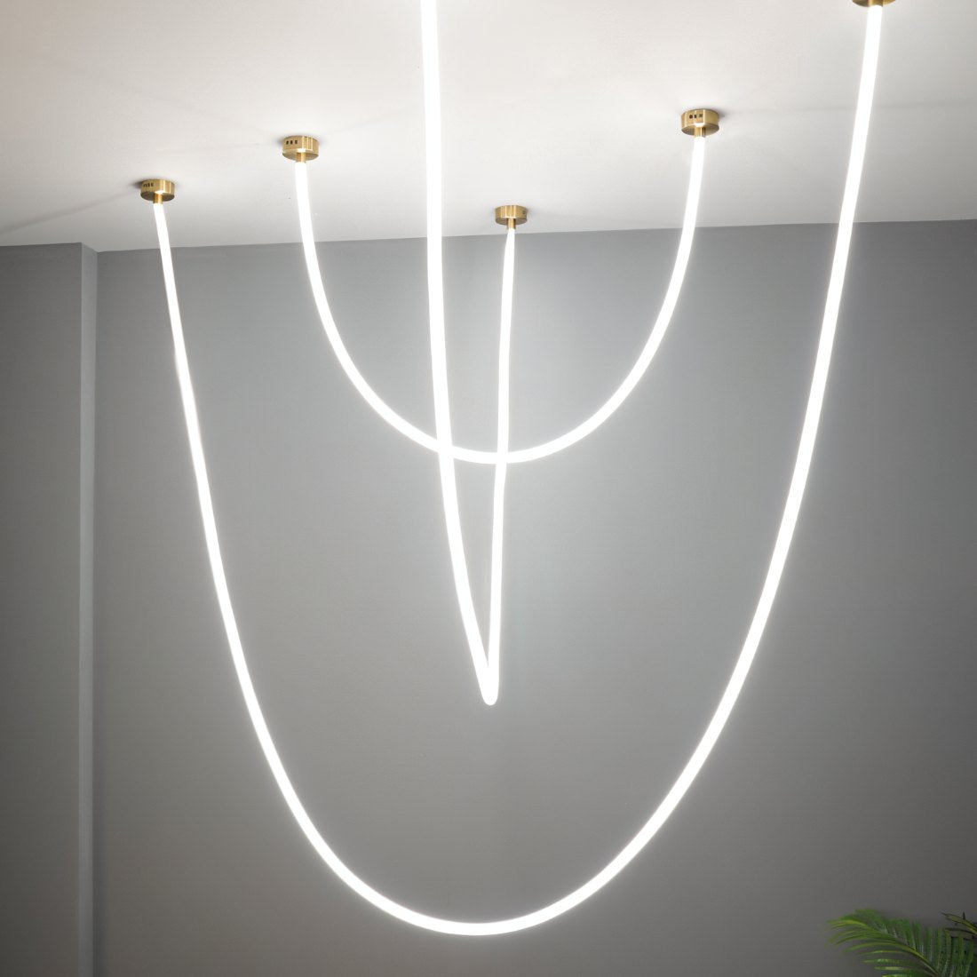 Clérachic black-capped flexible LED chandelier arcs above a walnut kitchen island with a curtained window.