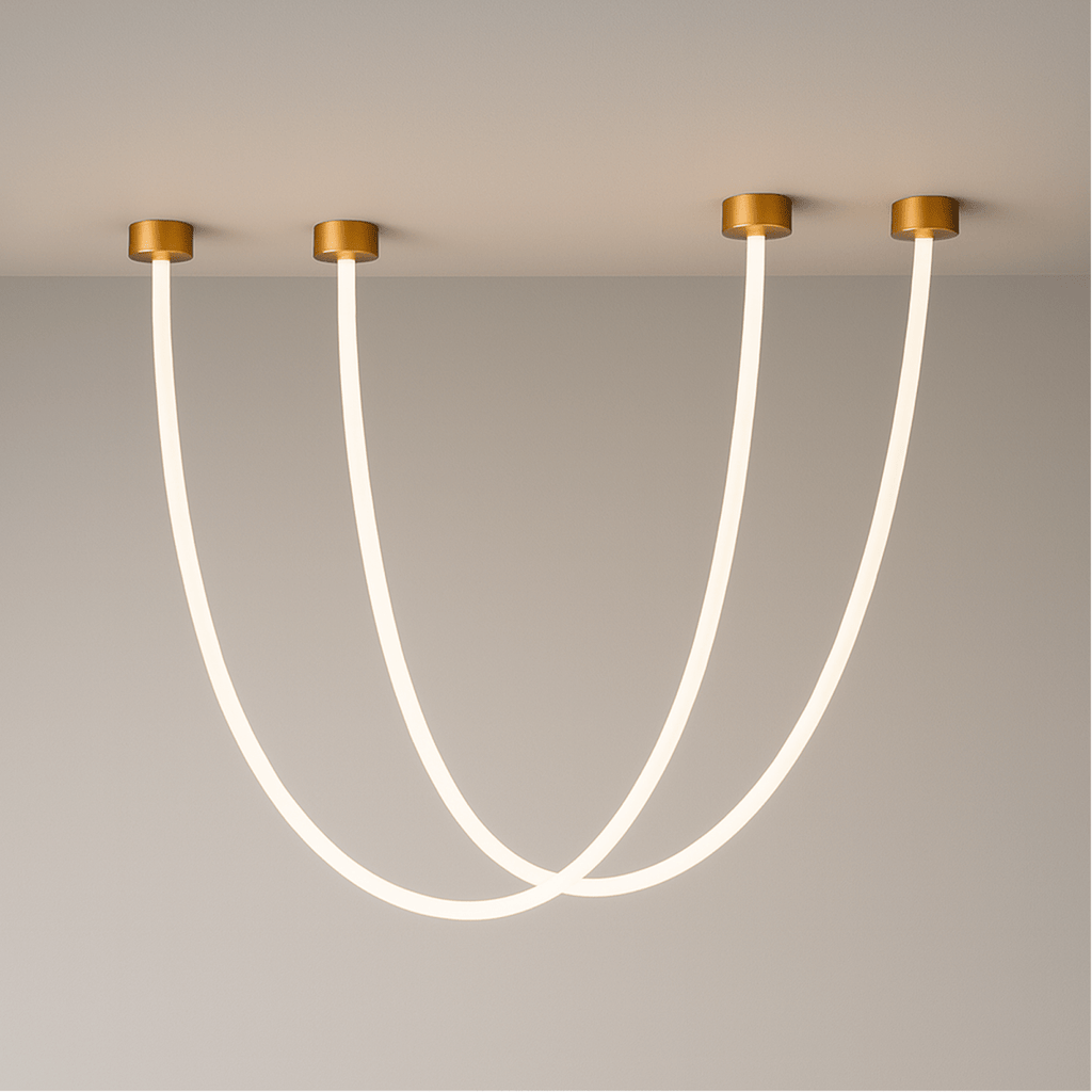 Clérachic gold-capped flexible LED chandelier arcs in three glowing loops of different lengths on a grey wall.