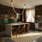 Clérachic black-capped flexible LED chandelier glows in a single loop above a dark kitchen island with green tile.