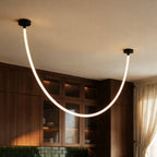 Close view of the Clérachic black-capped flexible LED chandelier looping past walnut glass-front cabinetry.