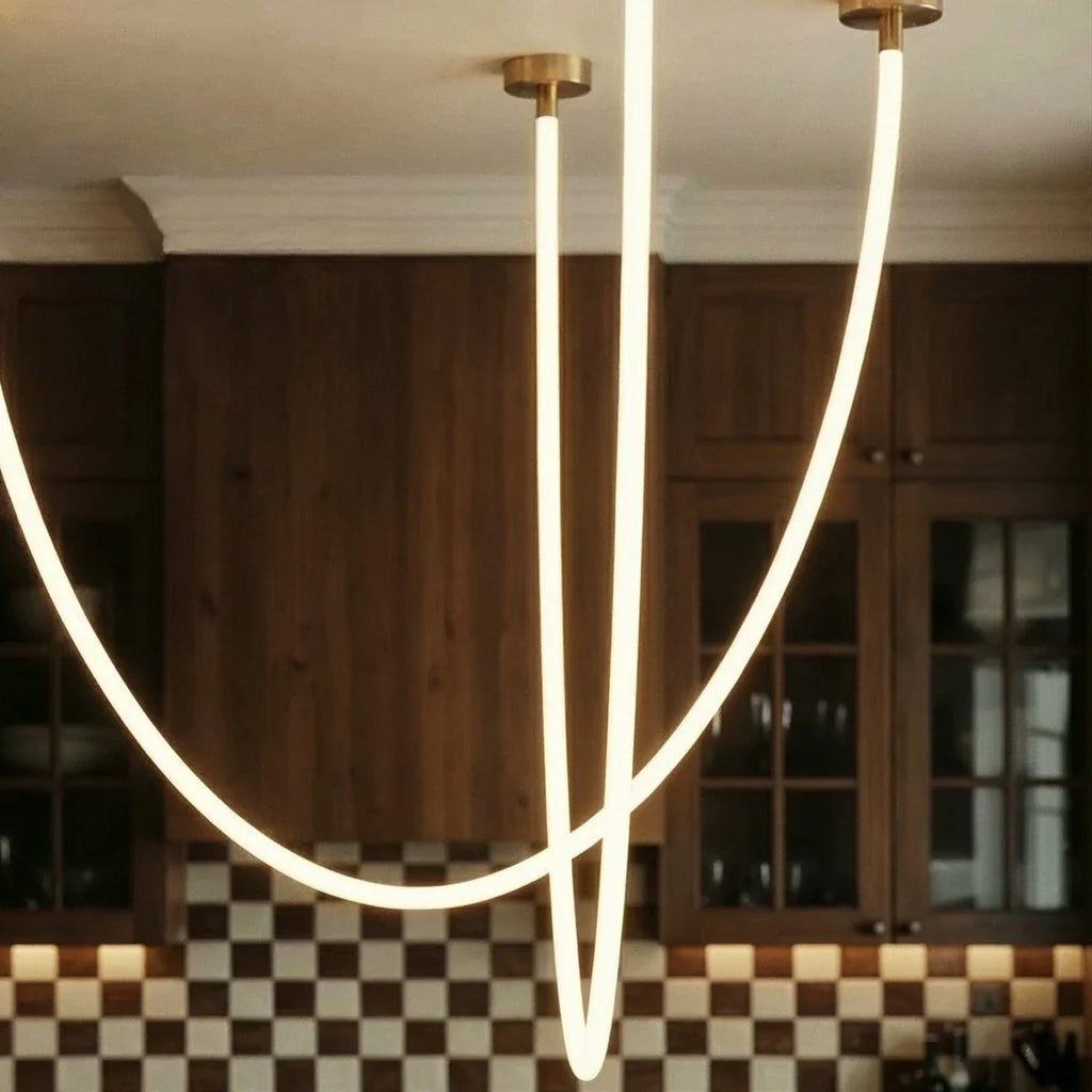 Close view of the Clérachic flexible LED chandelier's glowing loops against checkerboard tile and walnut cabinets.