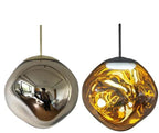Clérachic melt pendant in gold, mirrored outside and glowing amber when lit.