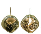 The Clérachic melt pendant in brass, shown mirrored and lit side by side.