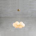The Clérachic Norduvyd in its smallest form, stone spheres packed tight and lit warm beneath a brass ceiling plate.