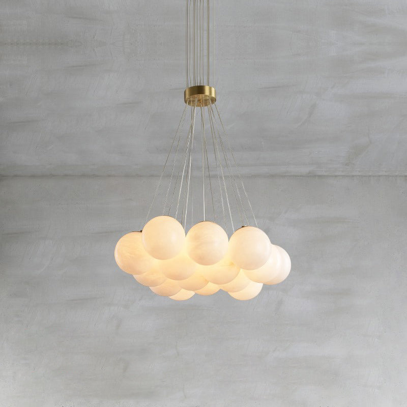 Clérachic suspends the Norduvyd on a long drop, brass canopy above and a soft raft of lit alabaster globes below.