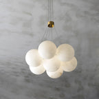 The Clérachic Norduvyd in a small cluster of oversized alabaster spheres, unlit against soft grey concrete.