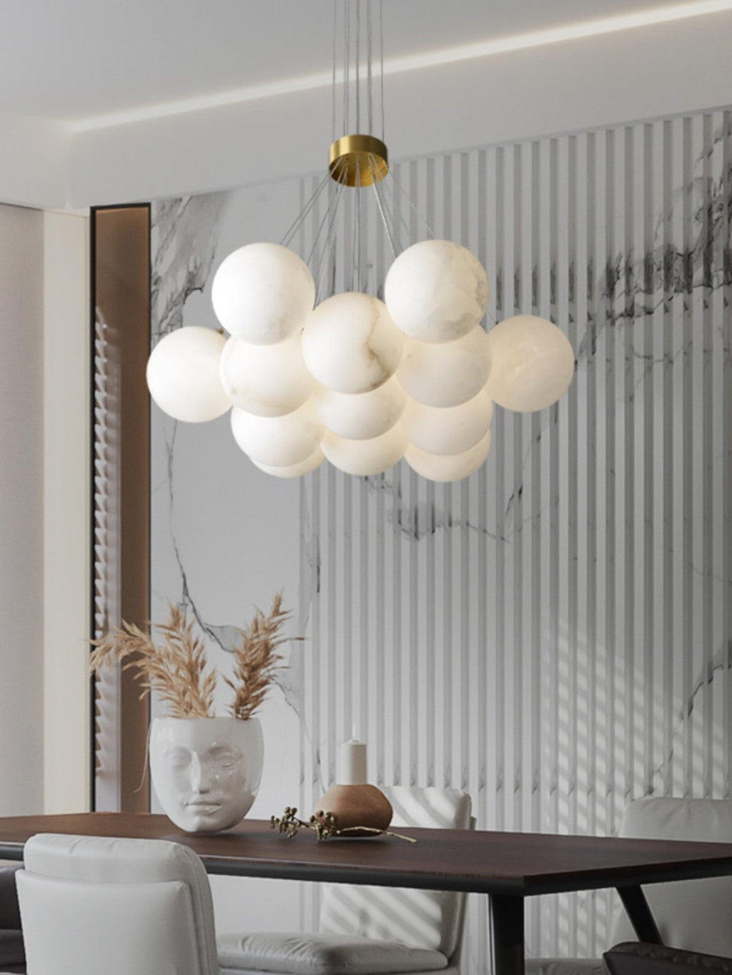 Clérachic floats the Norduvyd above a dark dining table, set against fluted marble and a tall vase of dried grass.