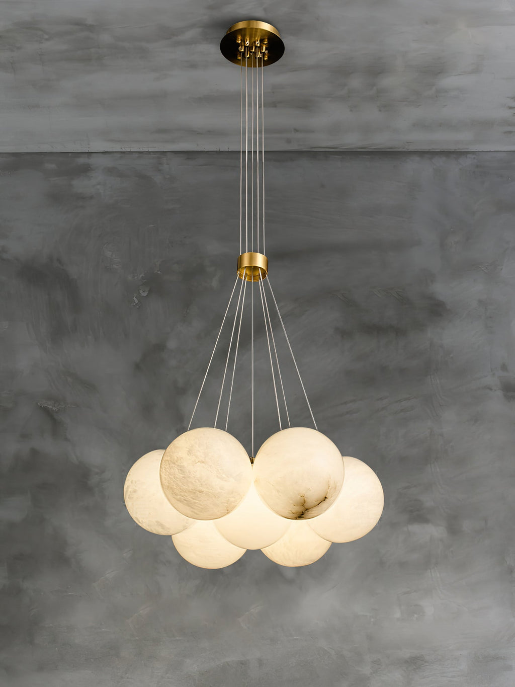 The Clérachic Norduvyd shown at its full 200 cm drop on concrete: ceiling plate, brass collar, then the globe cluster.