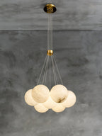 The Clérachic Norduvyd shown at its full 200 cm drop on concrete: ceiling plate, brass collar, then the globe cluster.