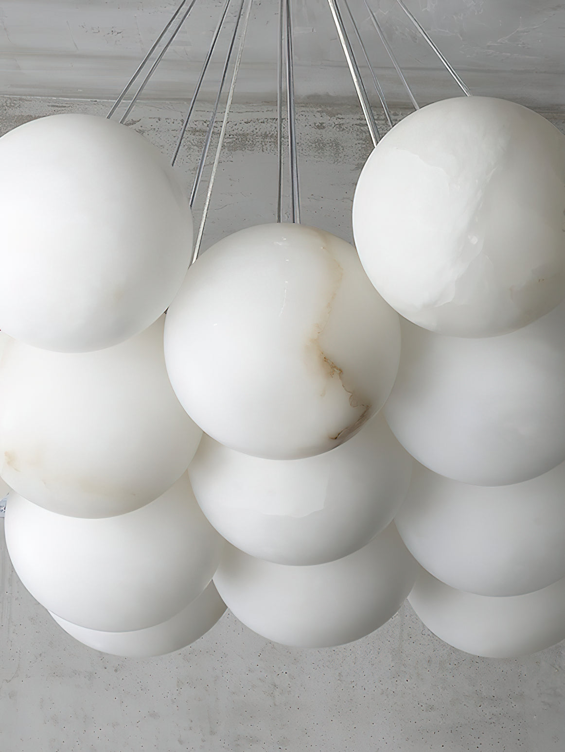 The Clérachic Norduvyd in close-up, soft grey veining running through the cool white alabaster of each globe.