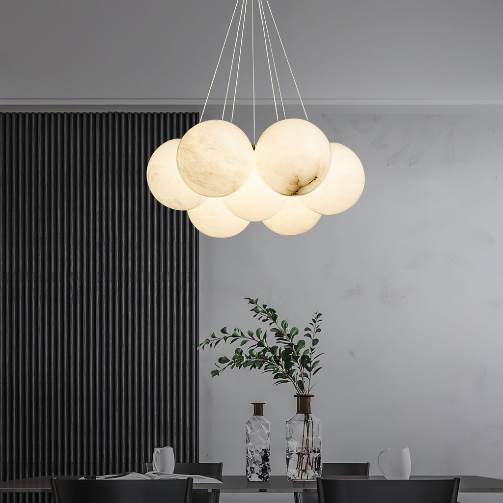 The Clérachic Norduvyd hangs above a dining table set with glass, against a dark fluted wall and pale plaster.