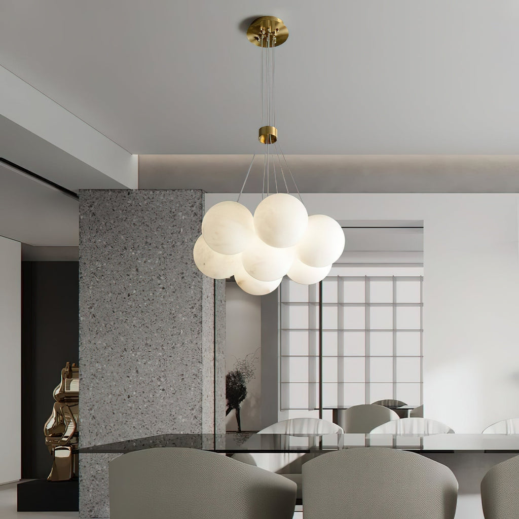 The Clérachic Norduvyd hangs in an open-plan dining space, its cluster mirrored in the stone and glass around it.