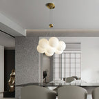 The Clérachic Norduvyd hangs in an open-plan dining space, its cluster mirrored in the stone and glass around it.