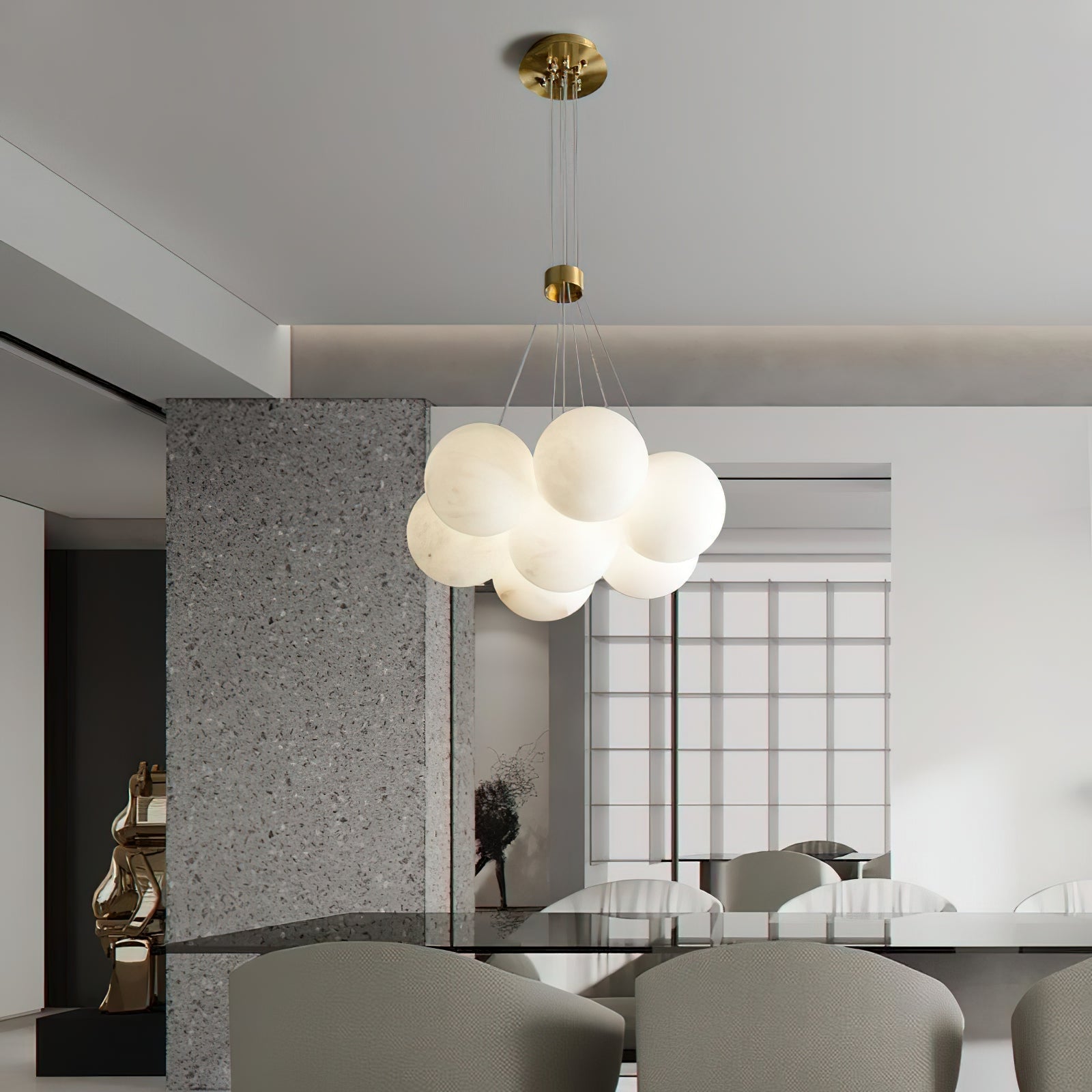 The Clérachic Norduvyd hangs in an open-plan dining space, its cluster mirrored in the stone and glass around it.