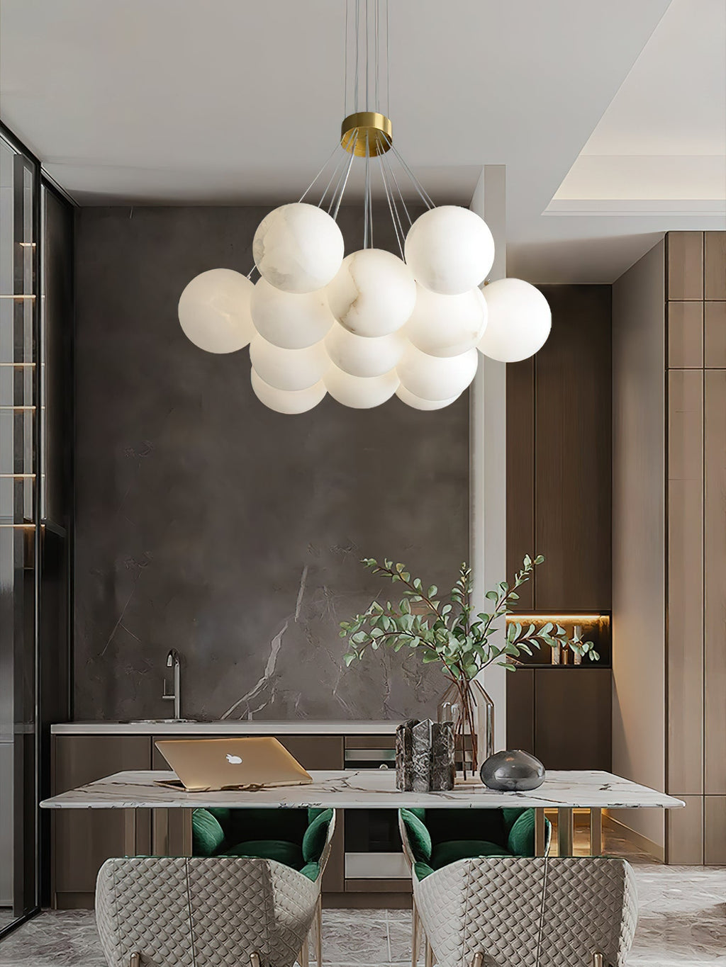 Clérachic sets the Norduvyd over a marble kitchen table with green velvet chairs and a dark stone backsplash.