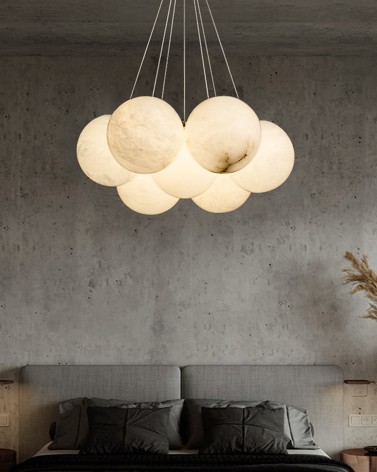 The Clérachic Norduvyd hangs over a bed against a raw concrete wall, its alabaster globes lit low and warm.